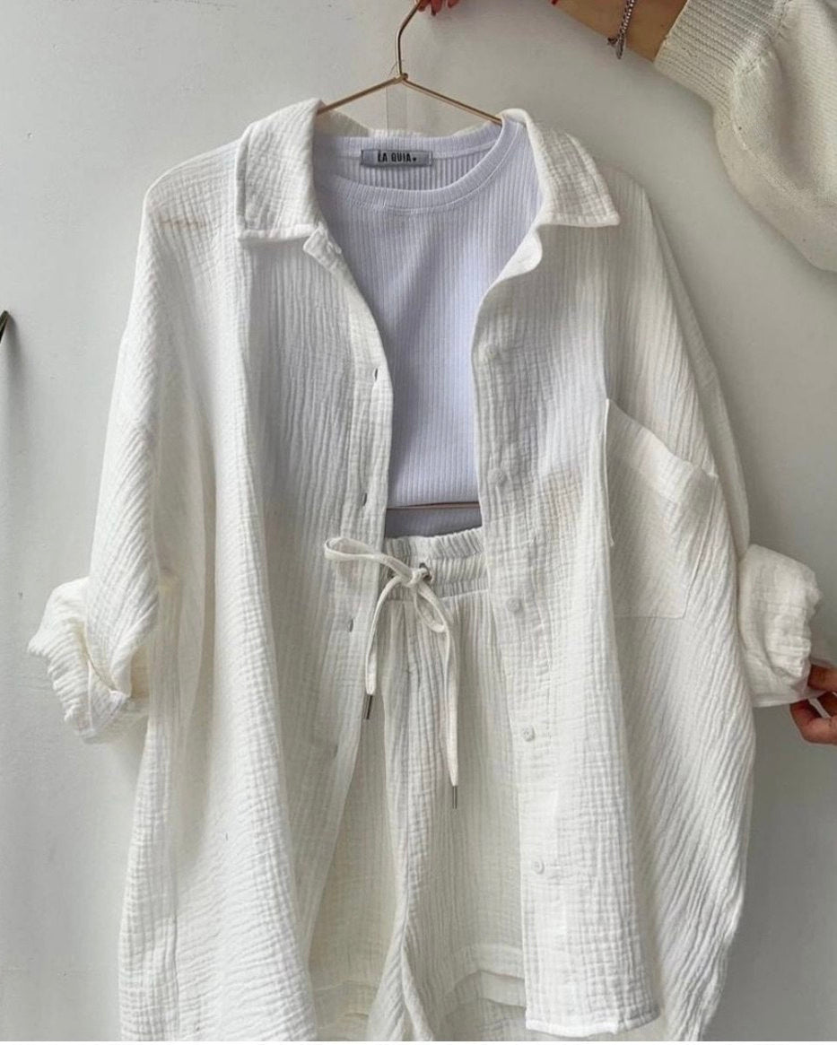 White textured shirt on a hanger against a plain background