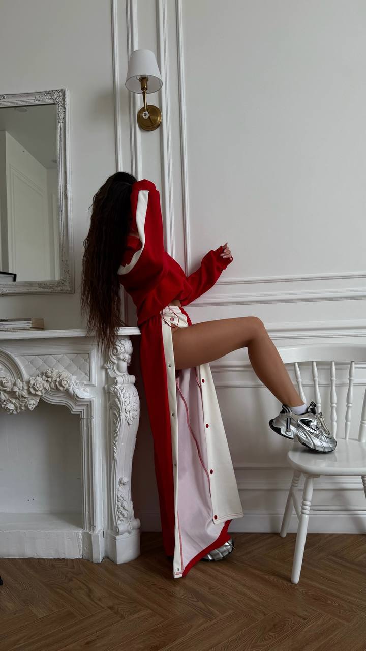 Sport suit Nola red two-piece with contrast side stripe, leaning pose