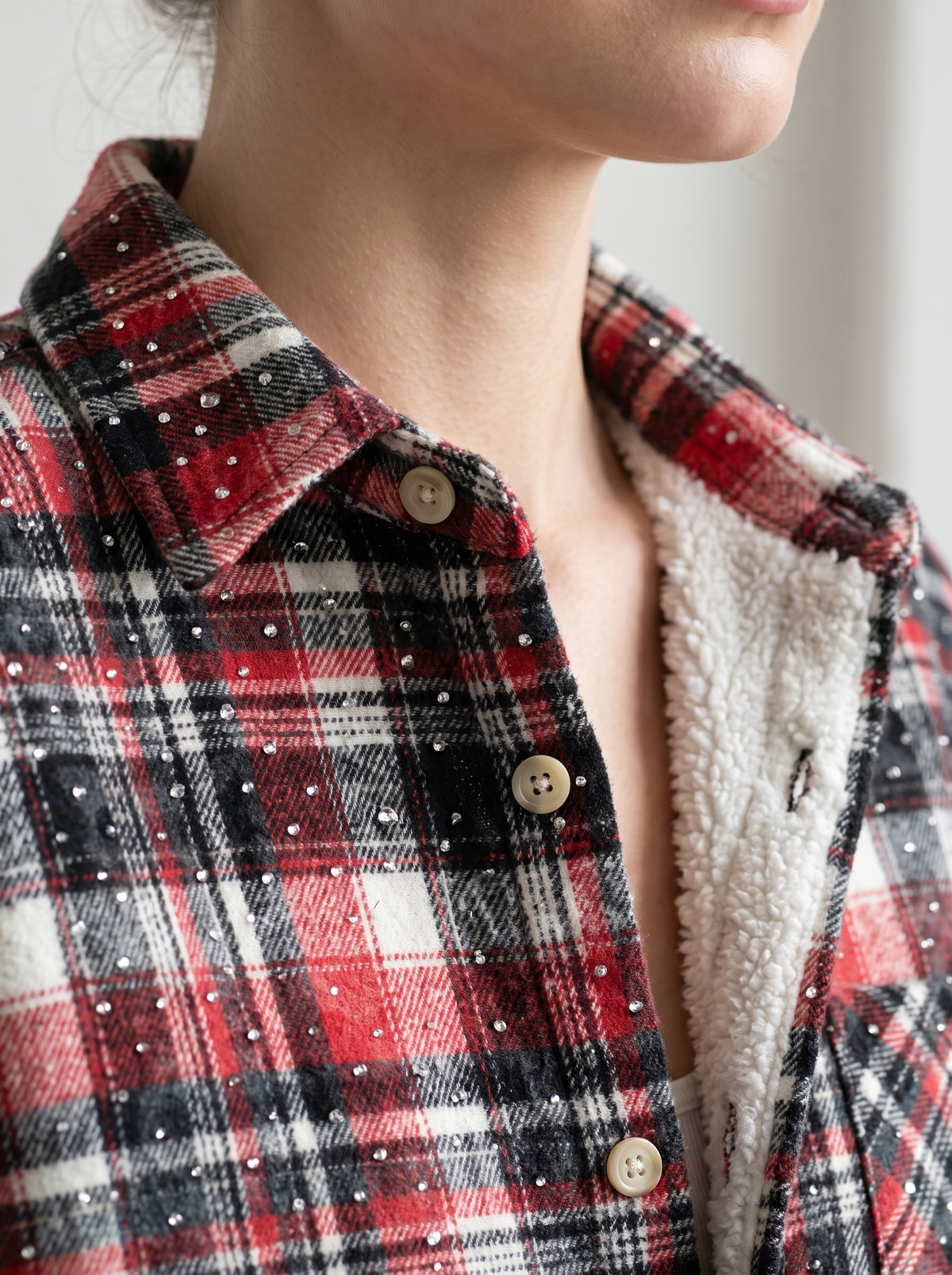 Red, black and dark green plaid rhinestone flannel shacket chest pocket detail, close-up