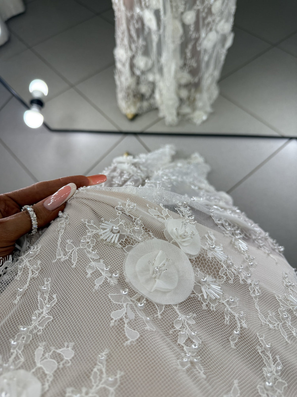 Detail of Chantilly guipure with 3D flowers, pearls and bugle beads on nude lining