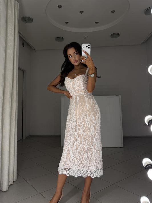 White Chantilly lace midi dress with pearl and bead embroidery, nude lining - front view, hand on hip
