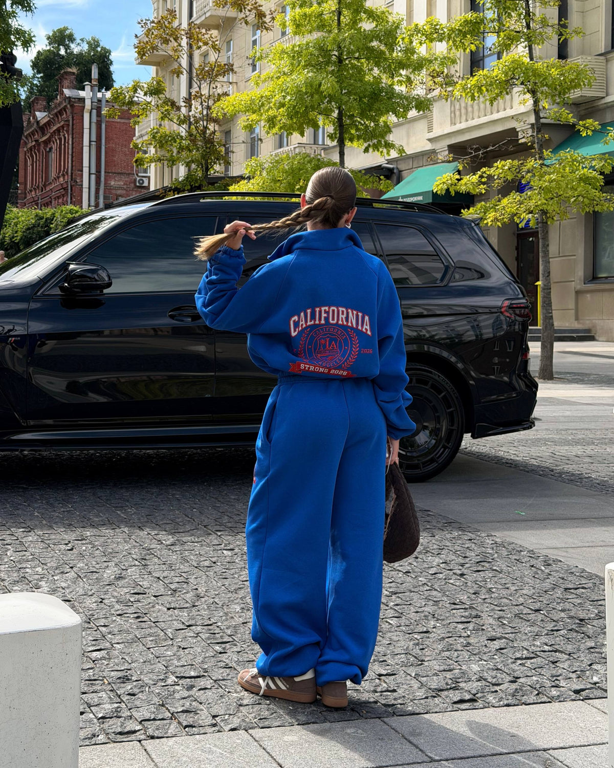 Blue oversized tracksuit - back view with large red and white crest print