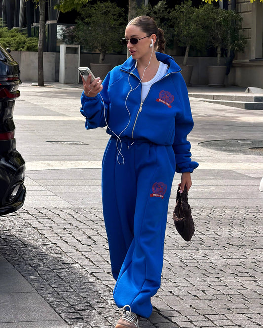 Blue fleece-lined tracksuit with red crest print - walking look with a white tank top