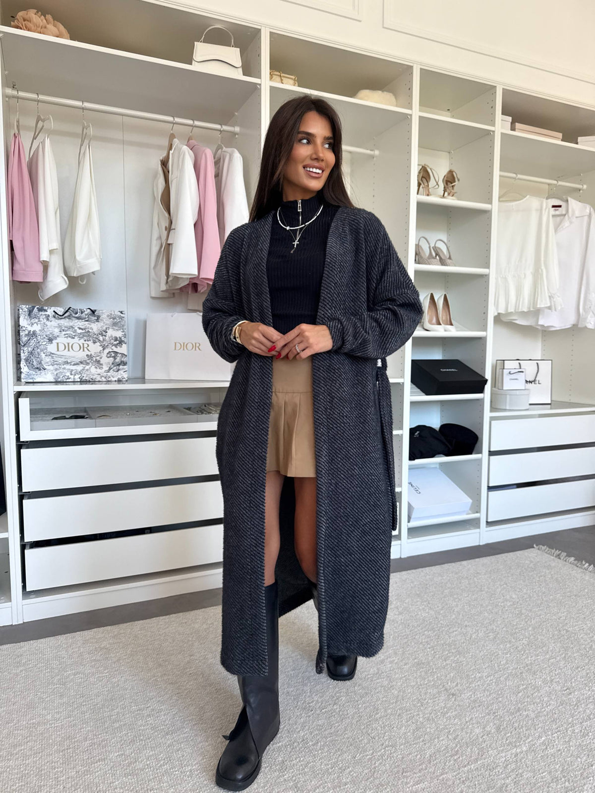 Charcoal gray ribbed knit long cardigan with self-tie belt, worn open over a black top and skirt, front view