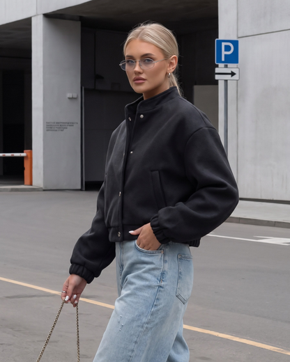 Black wool-blend cropped bomber jacket styled with wide-leg jeans - side view