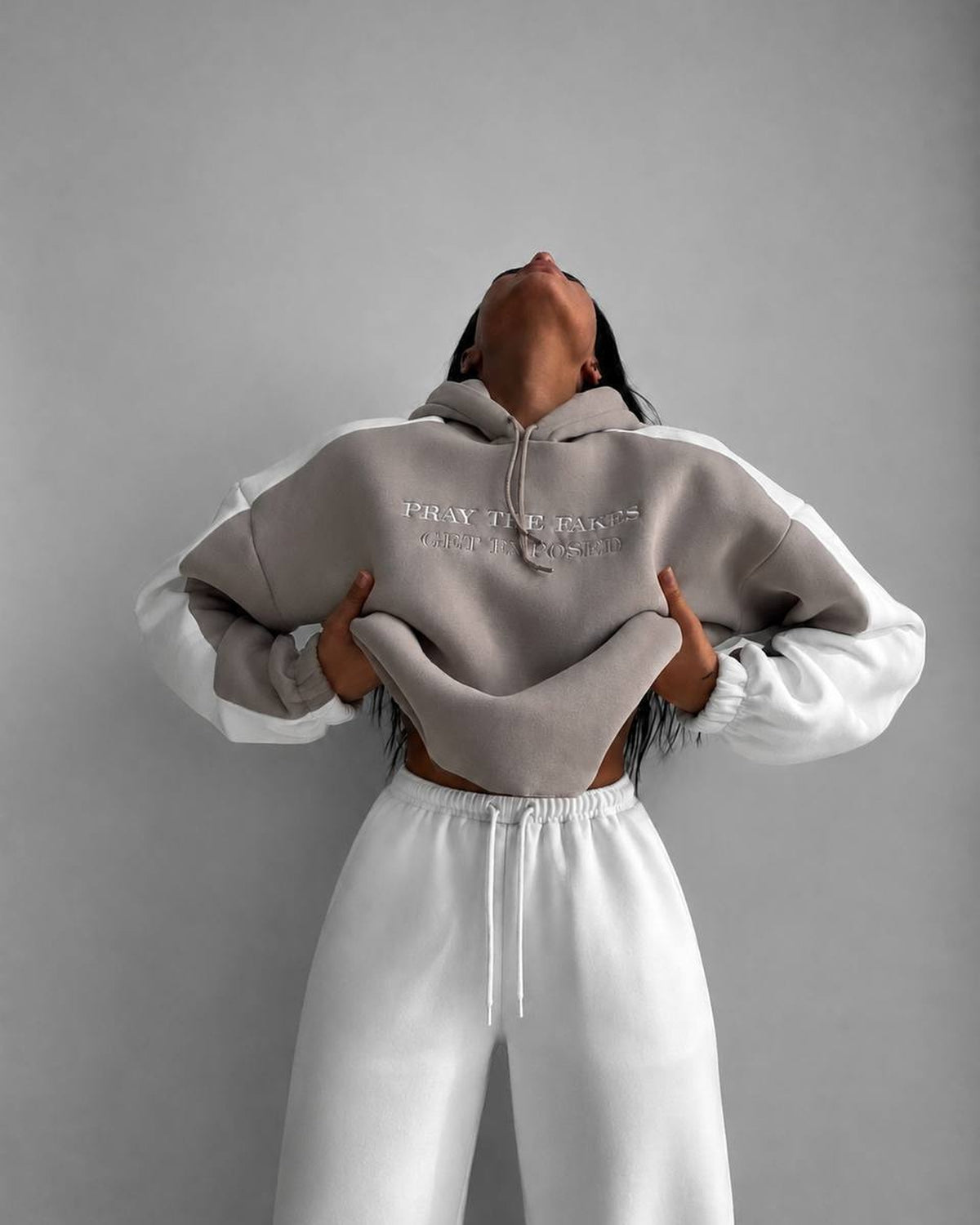 Beige cropped hoodie with milk sleeves and milk wide-leg joggers - front view with the hem lifted