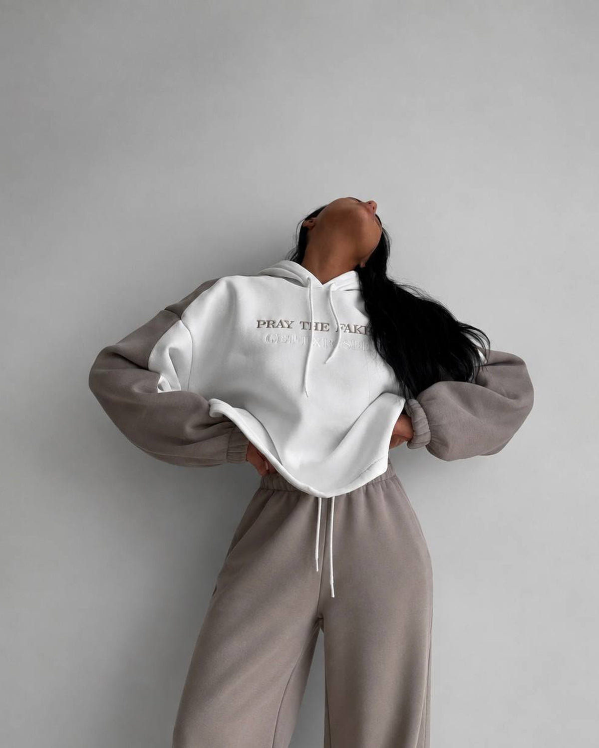 Milk-white cropped hoodie with beige sleeves and beige trousers - front view