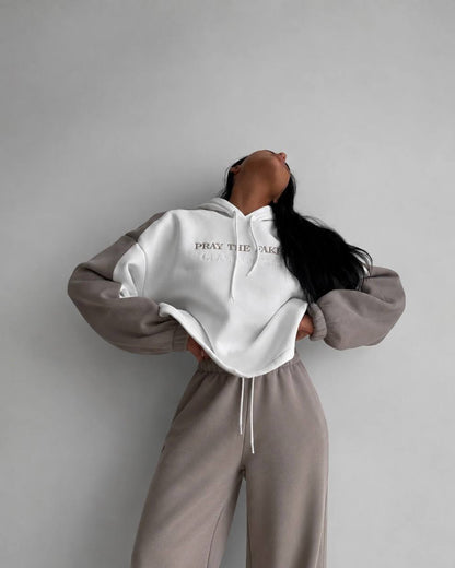 Milk-white cropped hoodie with beige sleeves and beige trousers - front view