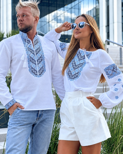 Man in a white vyshyvanka with blue embroidery standing next to a woman in a white blouse with blue embroidery