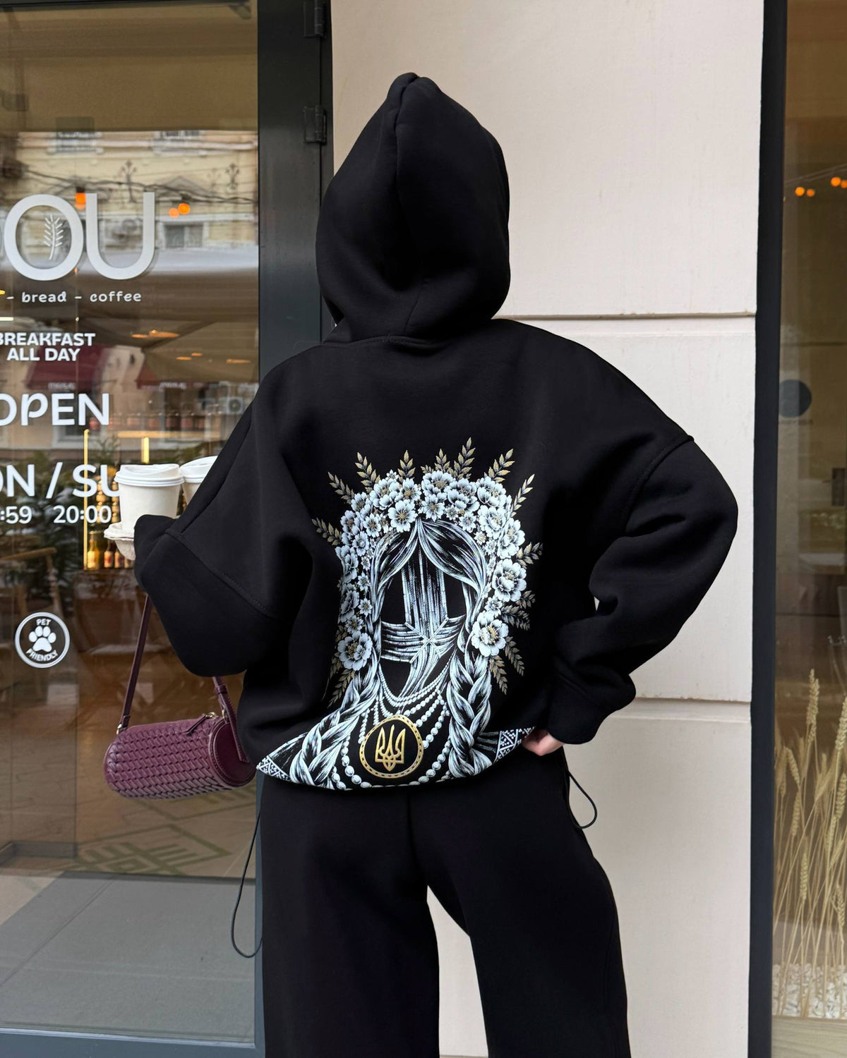 Black women's tracksuit with hoodie and wide trousers, back view with print