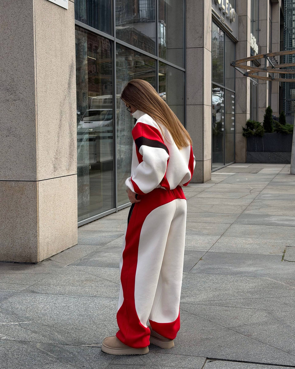Cream tracksuit with red hem panels and black sleeve stripes - view from the side and back