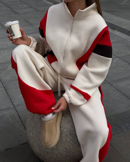 Cream fleece-lined tracksuit - seated close-up showing the zip jacket, roomy sleeves and red hem panels