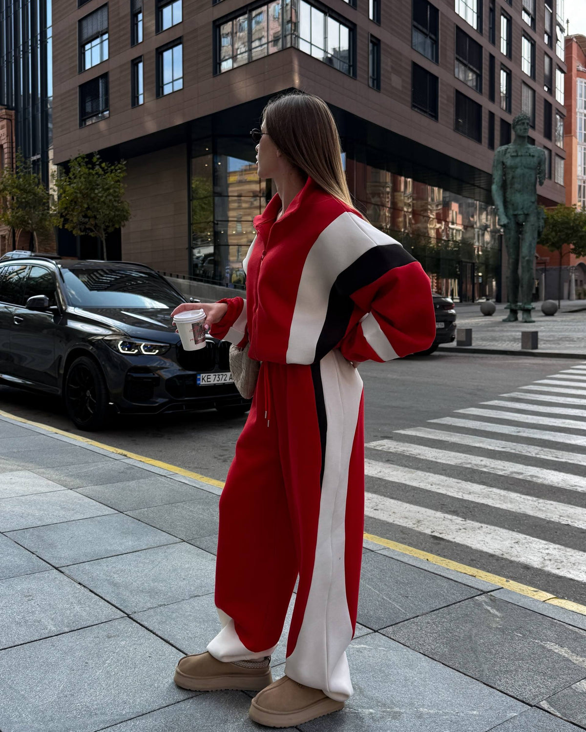 Red oversized zip jacket and wide-leg trousers with a cream side stripe - full-length street look