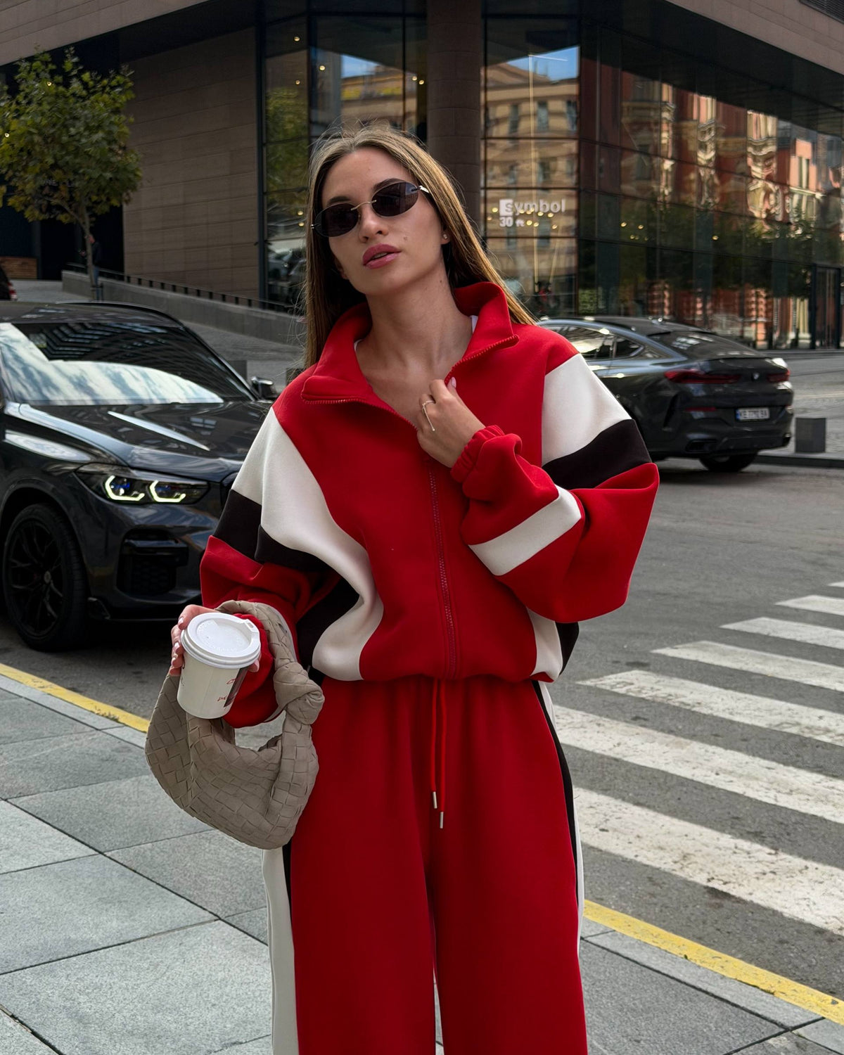 Red tracksuit with a high stand collar and cream and black sleeve panels - portrait with sunglasses