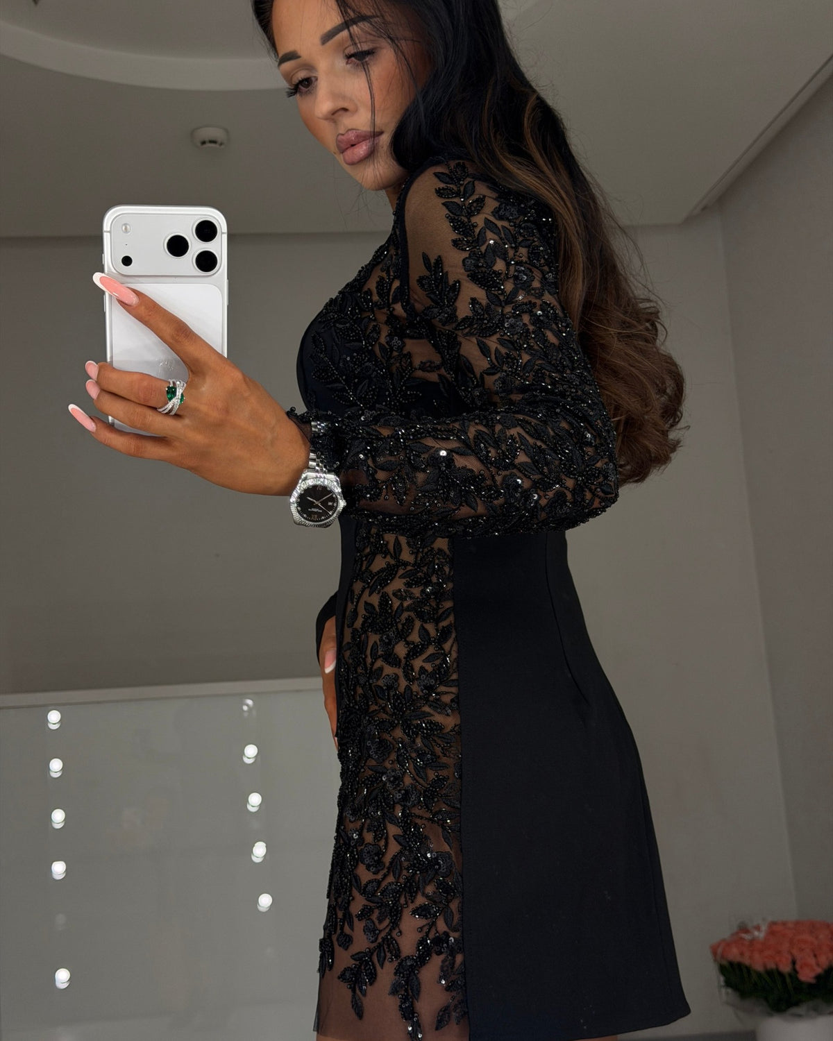 Black bandage knit mini dress with beaded embroidery and sheer insert, side view