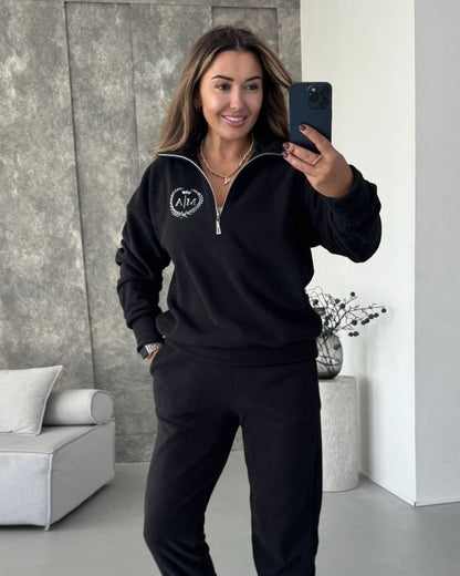 Black women's fleece tracksuit with half-zip sweatshirt and joggers, front view