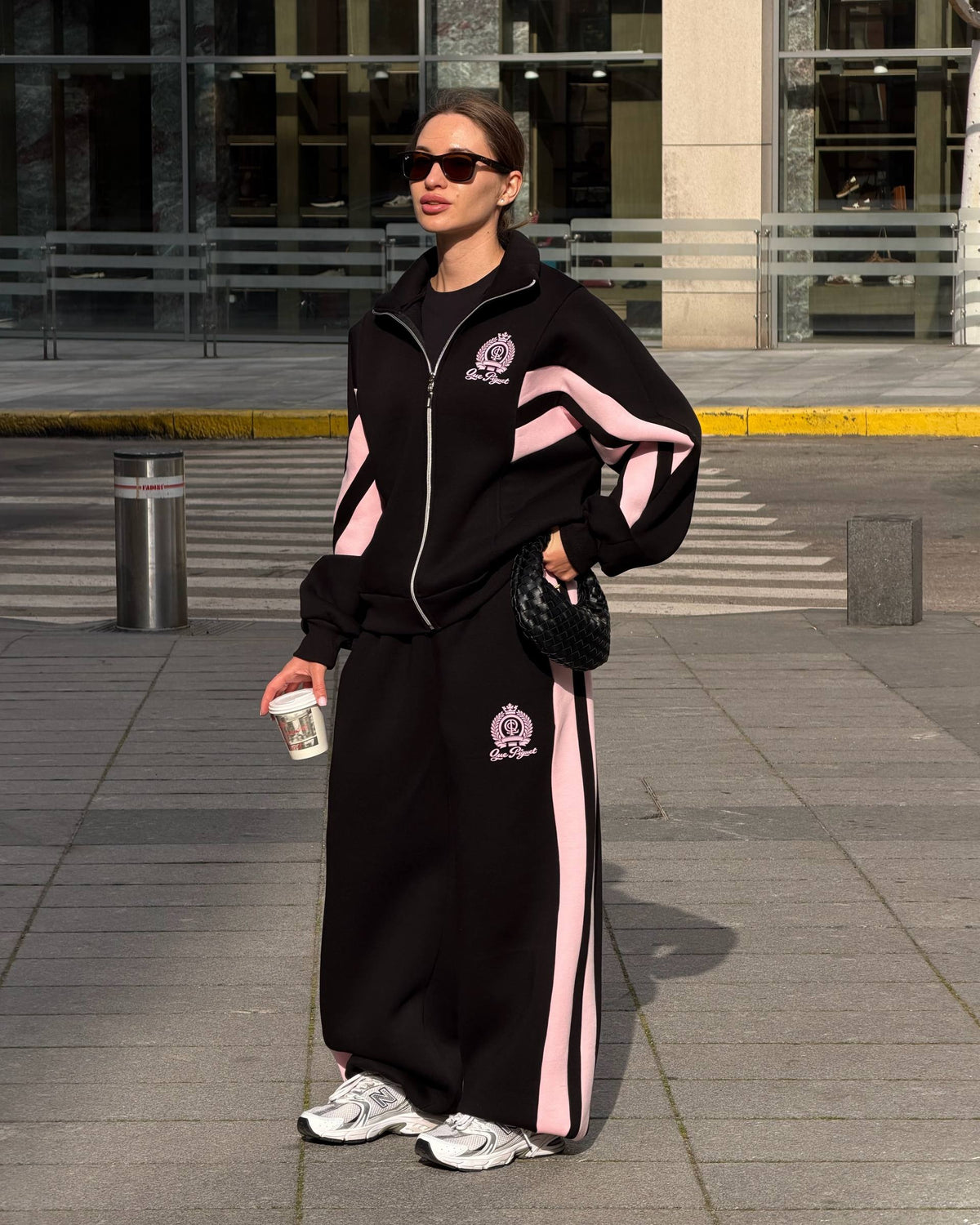 Black oversized zip jacket and wide-leg trousers with pink side stripes - full-length street look with sunglasses
