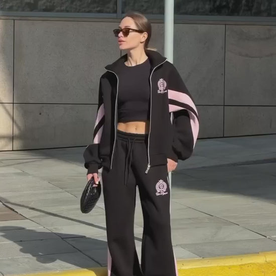 Short video of the black colour-block tracksuit with pink stripes worn on a city street
