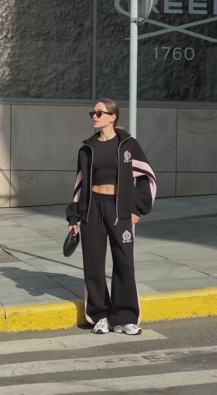 Short video of the black colour-block tracksuit with pink stripes worn on a city street