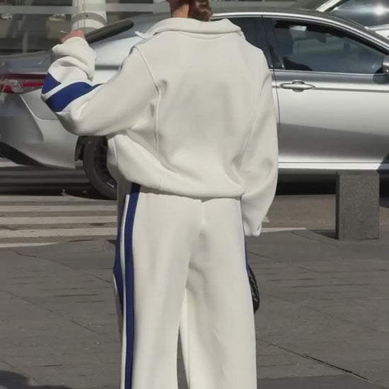 Short video of the milk-white colour-block tracksuit with blue stripes worn on a city street