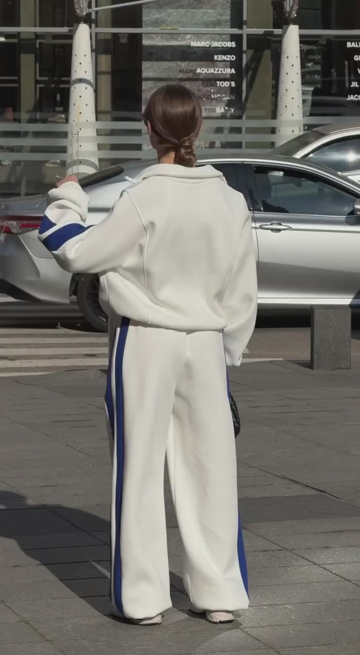 Short video of the milk-white colour-block tracksuit with blue stripes worn on a city street