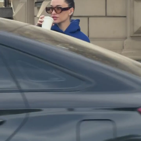 Short video of the blue oversized hoodie with white embroidery worn on a city street