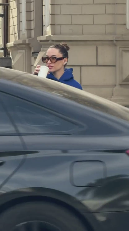 Short video of the blue oversized hoodie with white embroidery worn on a city street