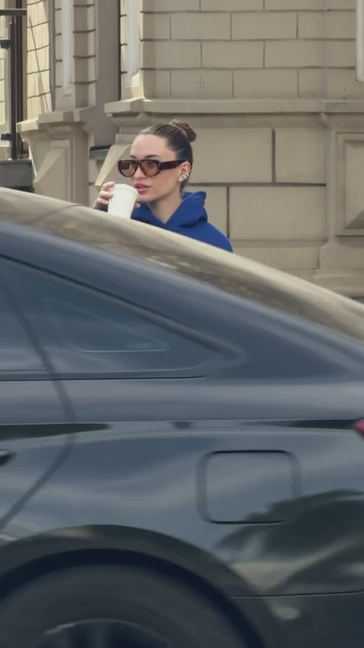 Short video of the blue oversized hoodie with white embroidery worn on a city street