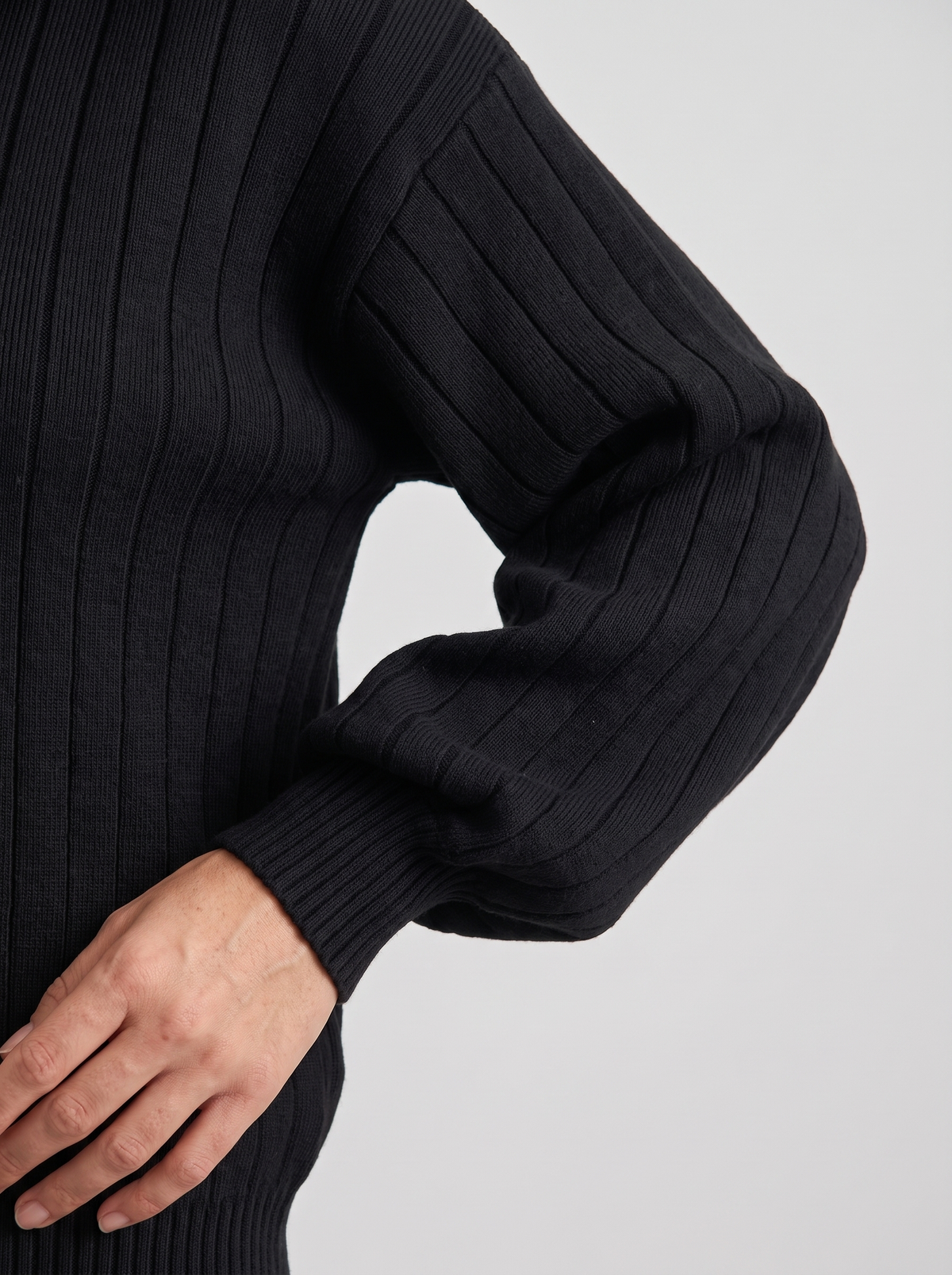 Detail of black ribbed knit sweatshirt sleeve and cuff