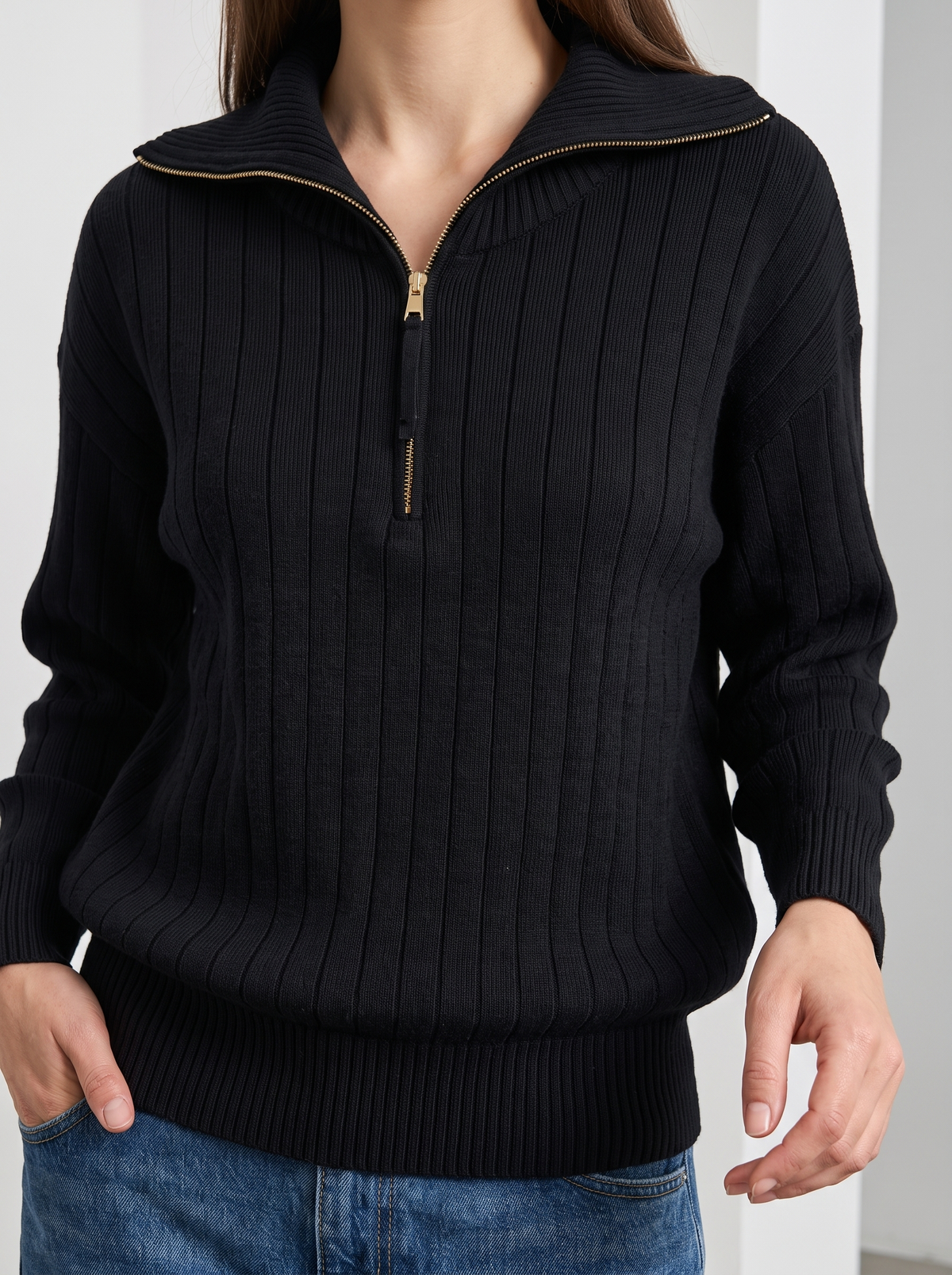 Woman wearing black ribbed knit half-zip sweatshirt, front view close-up on collar and zipper