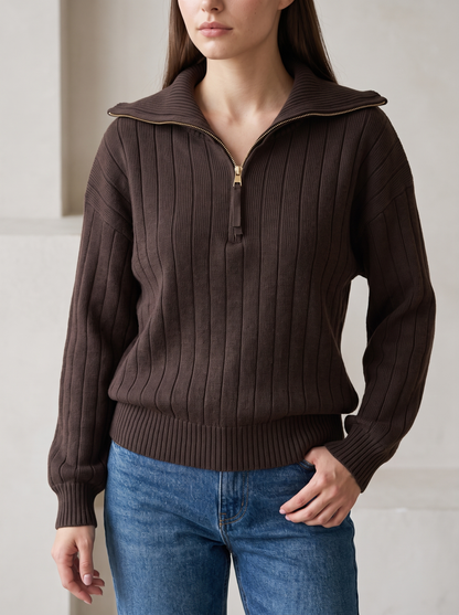 Woman wearing chocolate brown ribbed knit half-zip sweatshirt, front view with jeans
