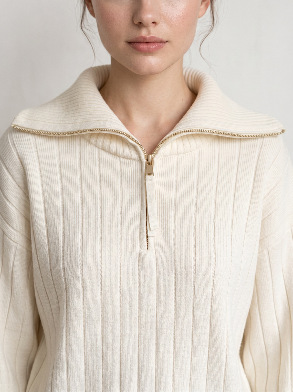 Close-up of cream ribbed knit sweatshirt funnel collar and zipper
