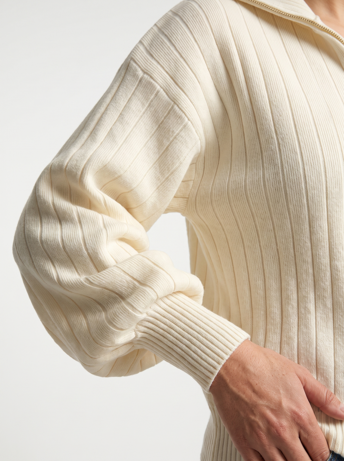 Detail of cream ribbed knit sweatshirt sleeve and cuff