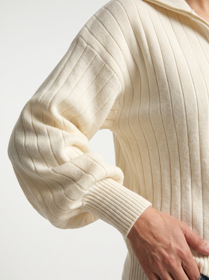 Detail of cream ribbed knit sweatshirt sleeve and cuff