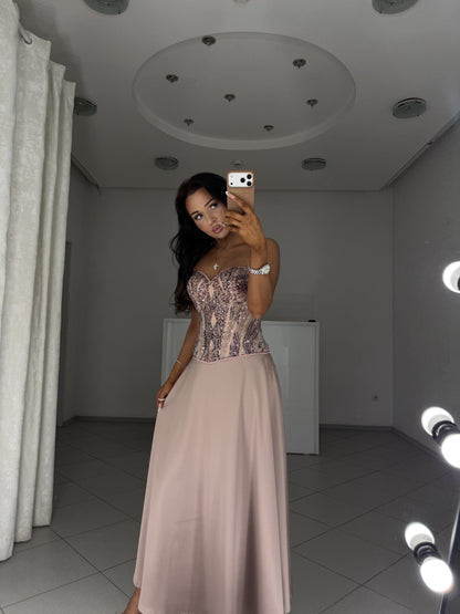 Tessa outfit set - beaded corset and half-circle satin midi skirt, hand resting on the skirt