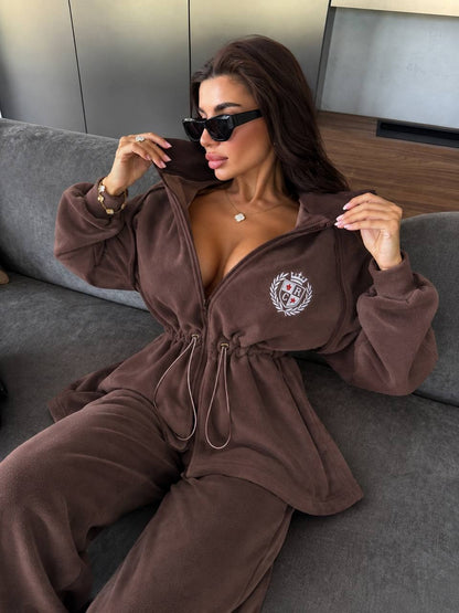 Mocha fleece tracksuit "Vessa" with embroidered crest - model sitting, zip jacket with drawstring waist